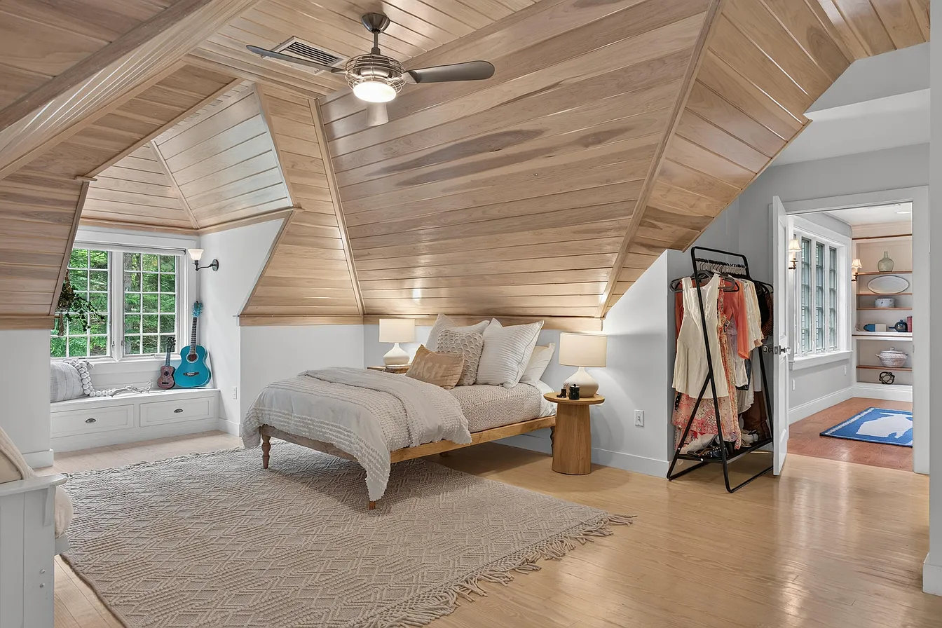 Pale wood vaulted ceiling following the roofline of a bedroom retreat