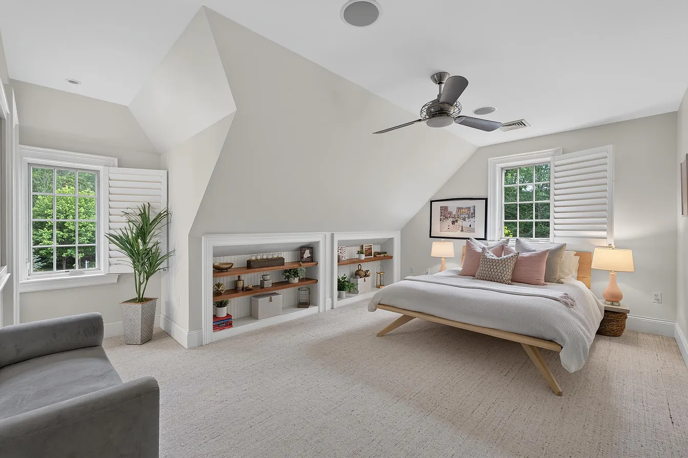 Custom low built-in shelves fitted beneath the sloping bedroom ceiling