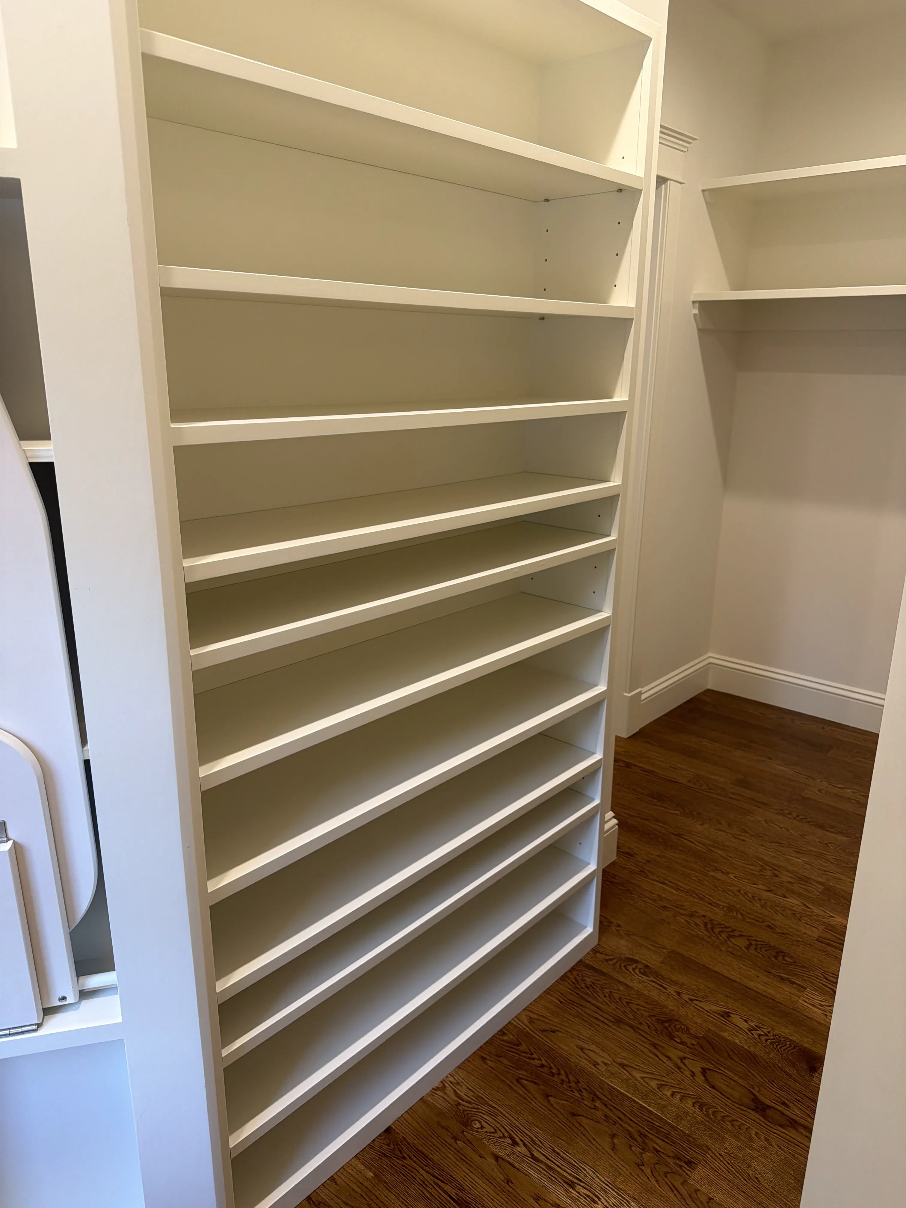 Custom fitted shelving inside a finished walk-in closet