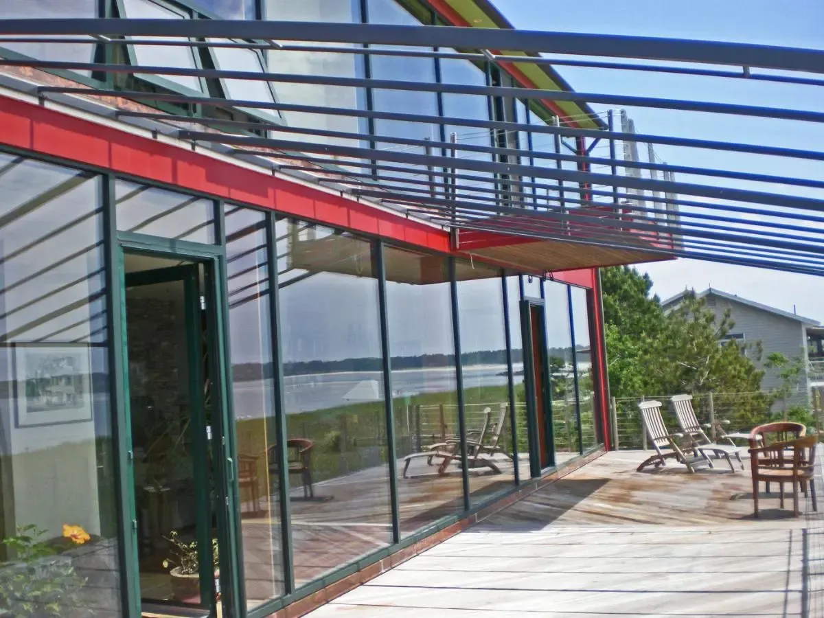 Expansive glass doors open onto the home's deck overlooking the coast