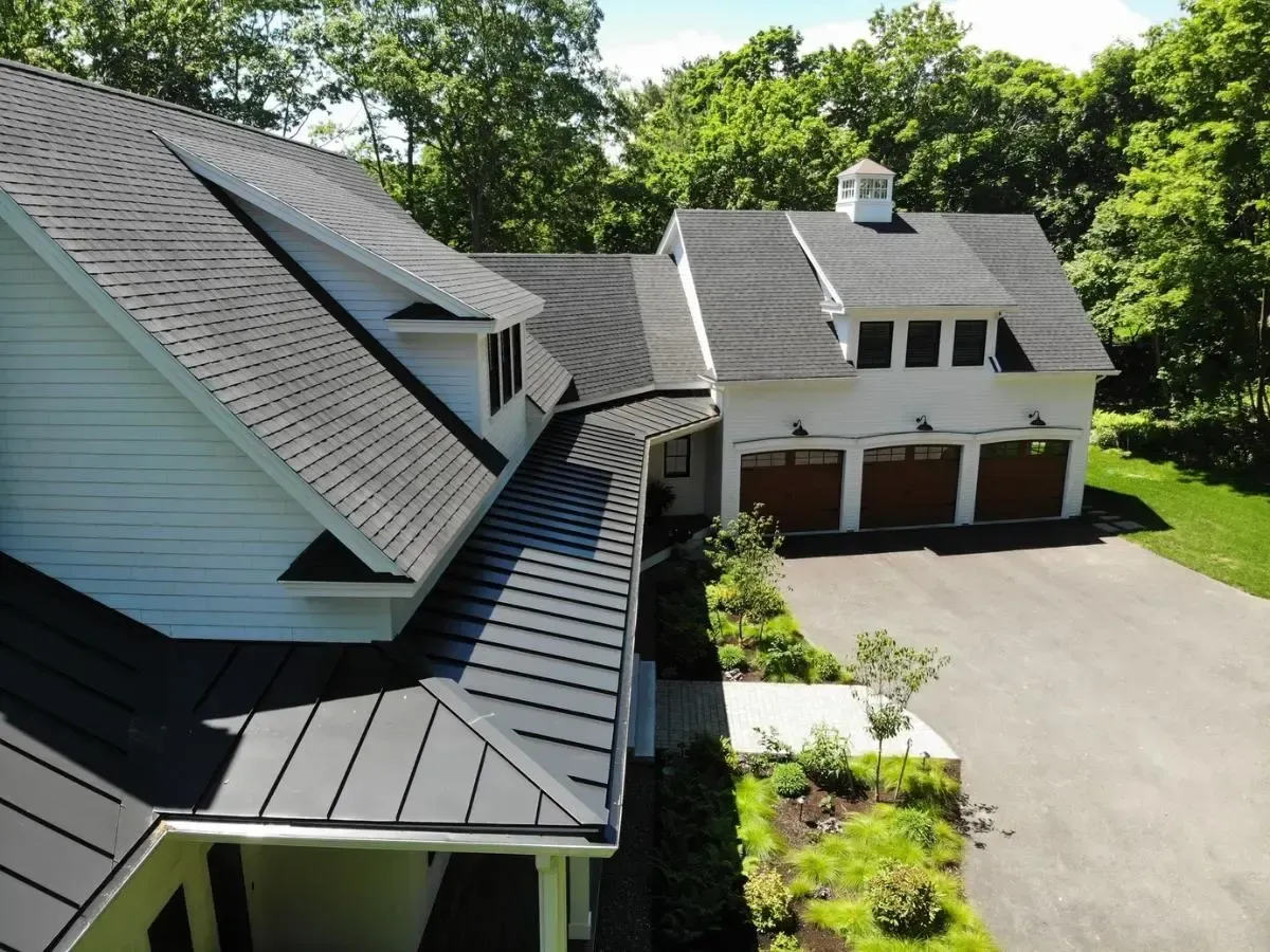 Aerial view of the white Cape cottage and dark roof
