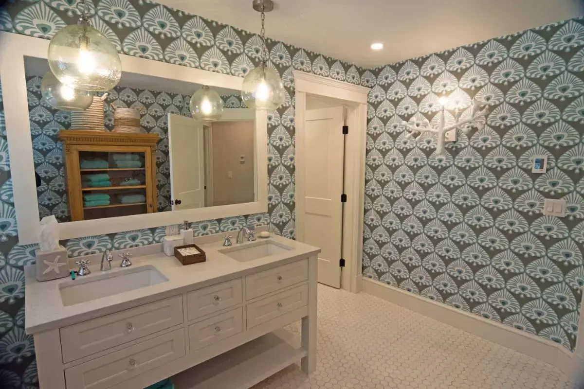 Bathroom with a double vanity, mirror, and blue-and-white wallpaper