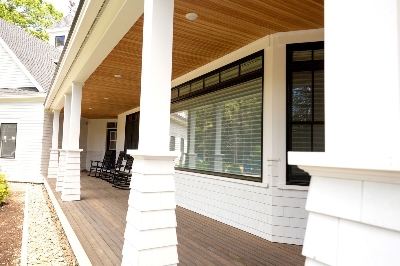 Front porch with rocking chairs beside a large window