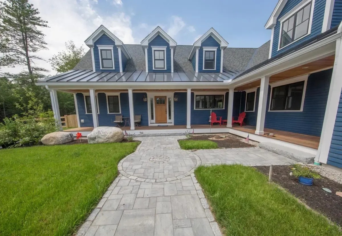 Blue home with a brick walkway to the front entrance