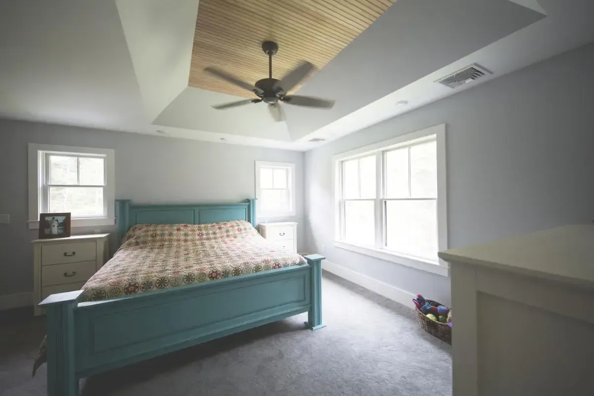 Bedroom with a blue bed and ceiling fan