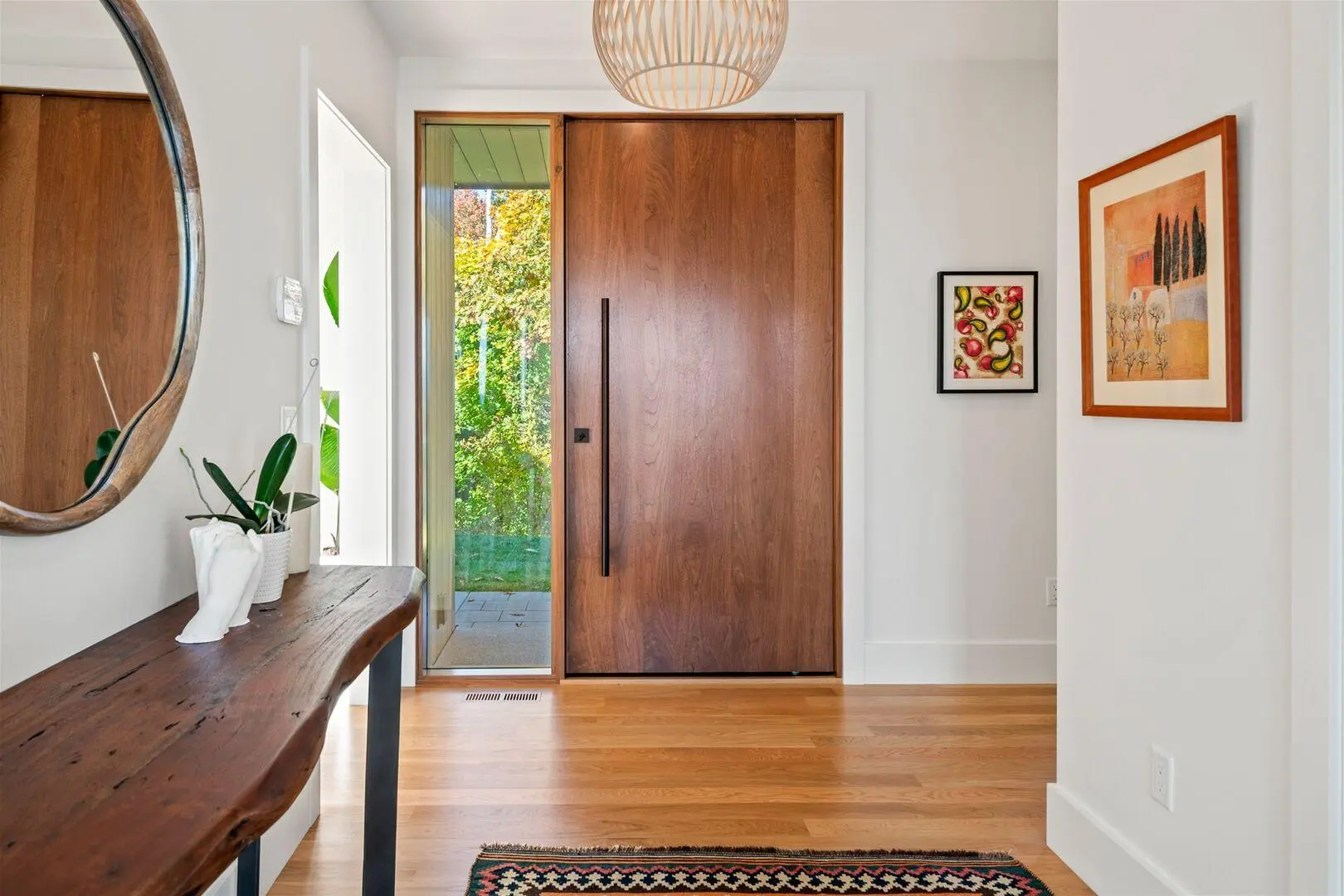 Custom walnut entry door with a long dark handle and natural wood grain