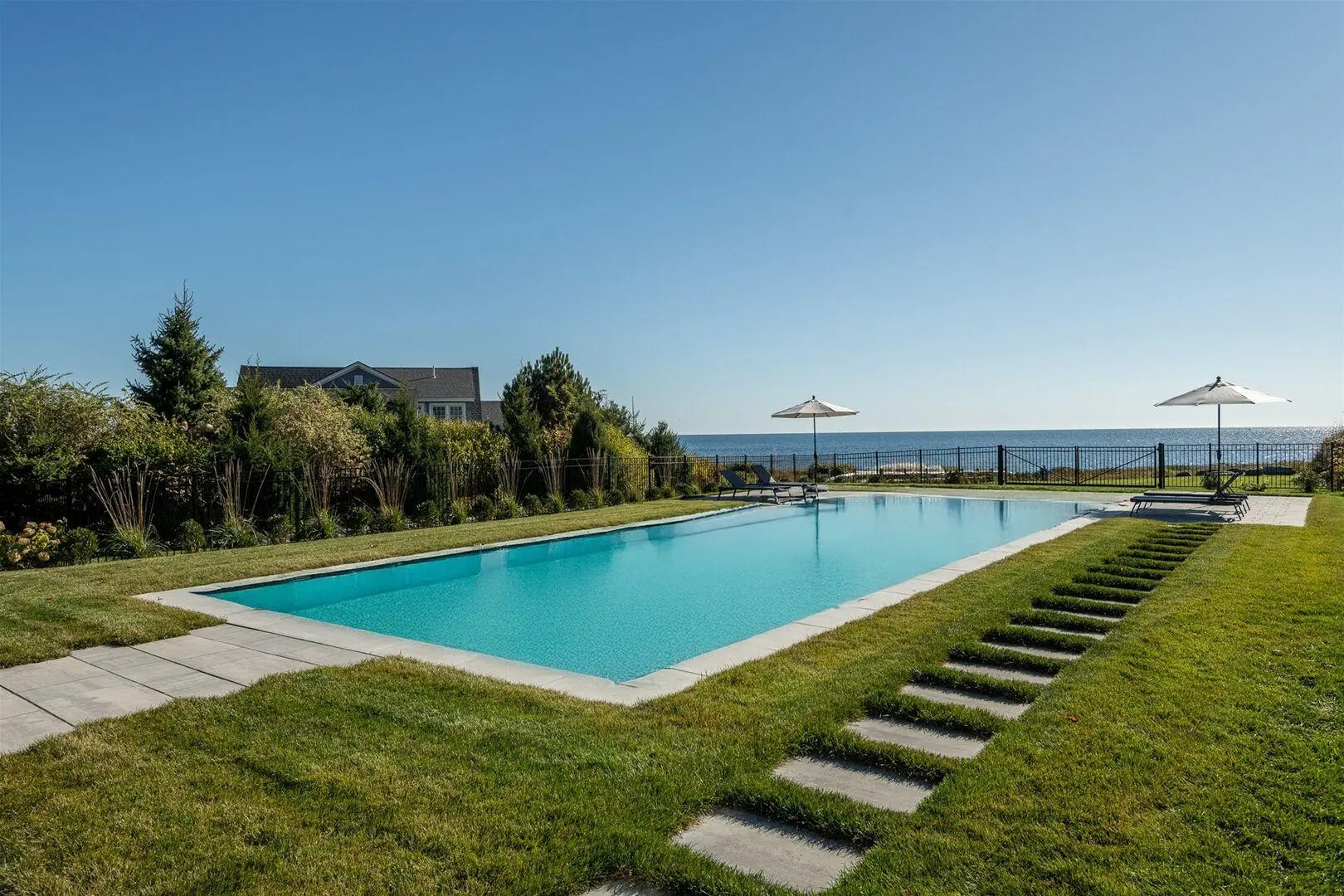Coastal residence with a long swimming pool and ocean beyond the lawn