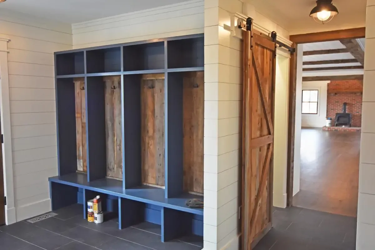 Hallway with a sliding barn door and built-in lockers
