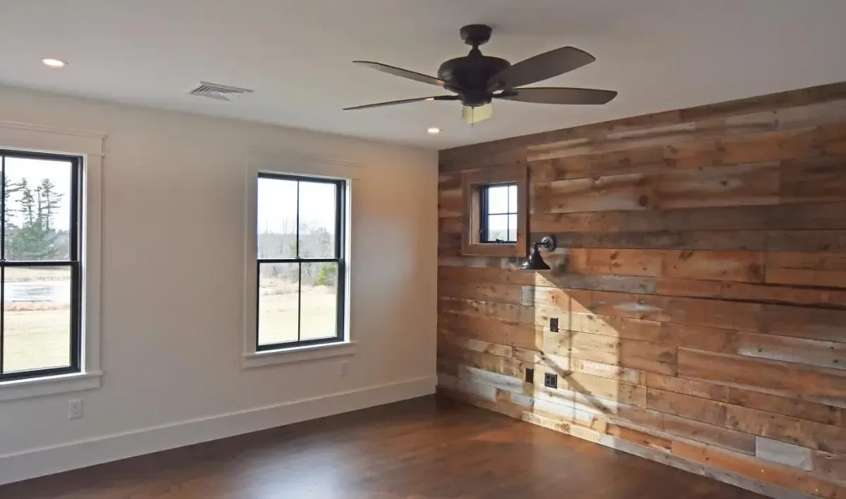 Unfurnished room with a wood accent wall and ceiling fan
