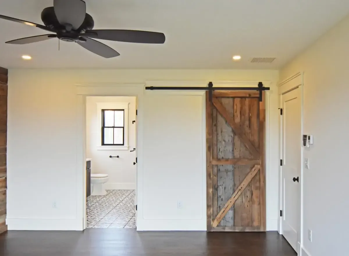 Room with a ceiling fan and sliding barn door