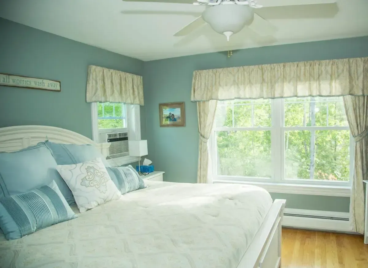 Bedroom with blue walls, a ceiling fan, and a window