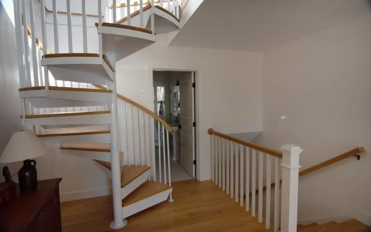 Spiral staircase with wood treads and a white railing