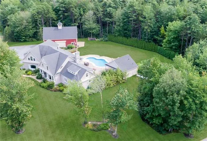 Aerial view of the home, pool, and red barn on the estate grounds