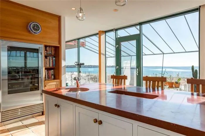 Kitchen island and dining area framed by coastal windows