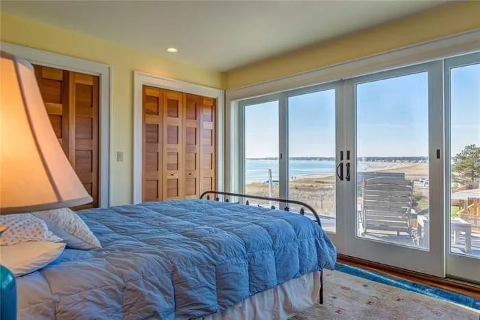 Bedroom with a blue bed and daylight from large windows