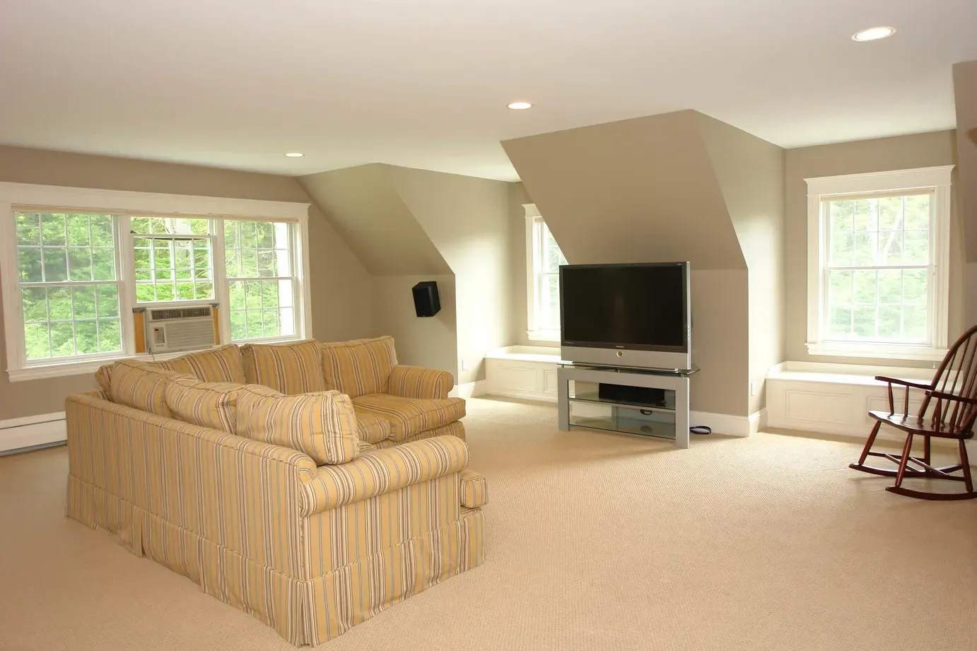 Living room with a sofa, armchair, rocking chair, and television