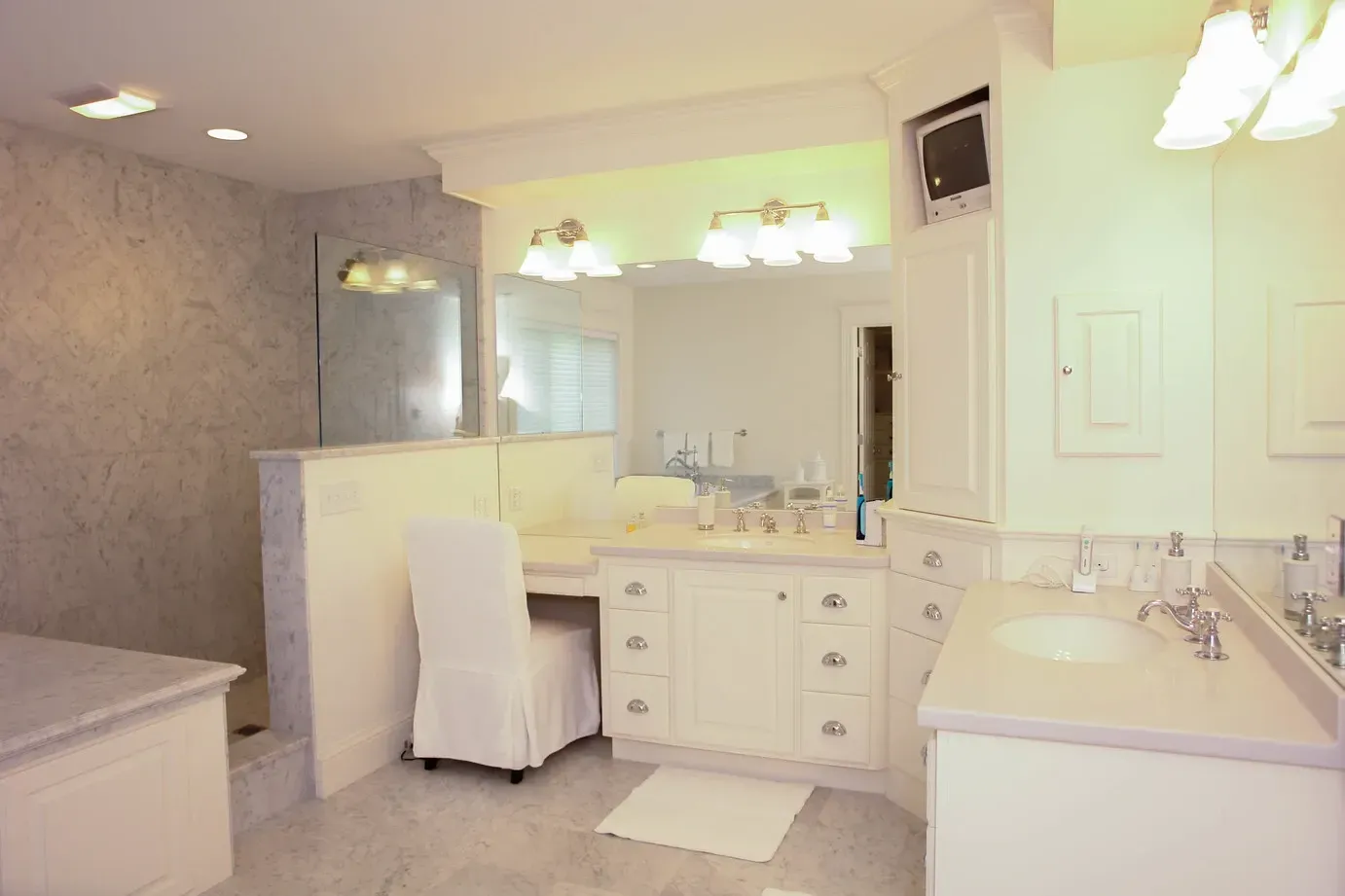 Bathroom with a double vanity, tub, and large mirror