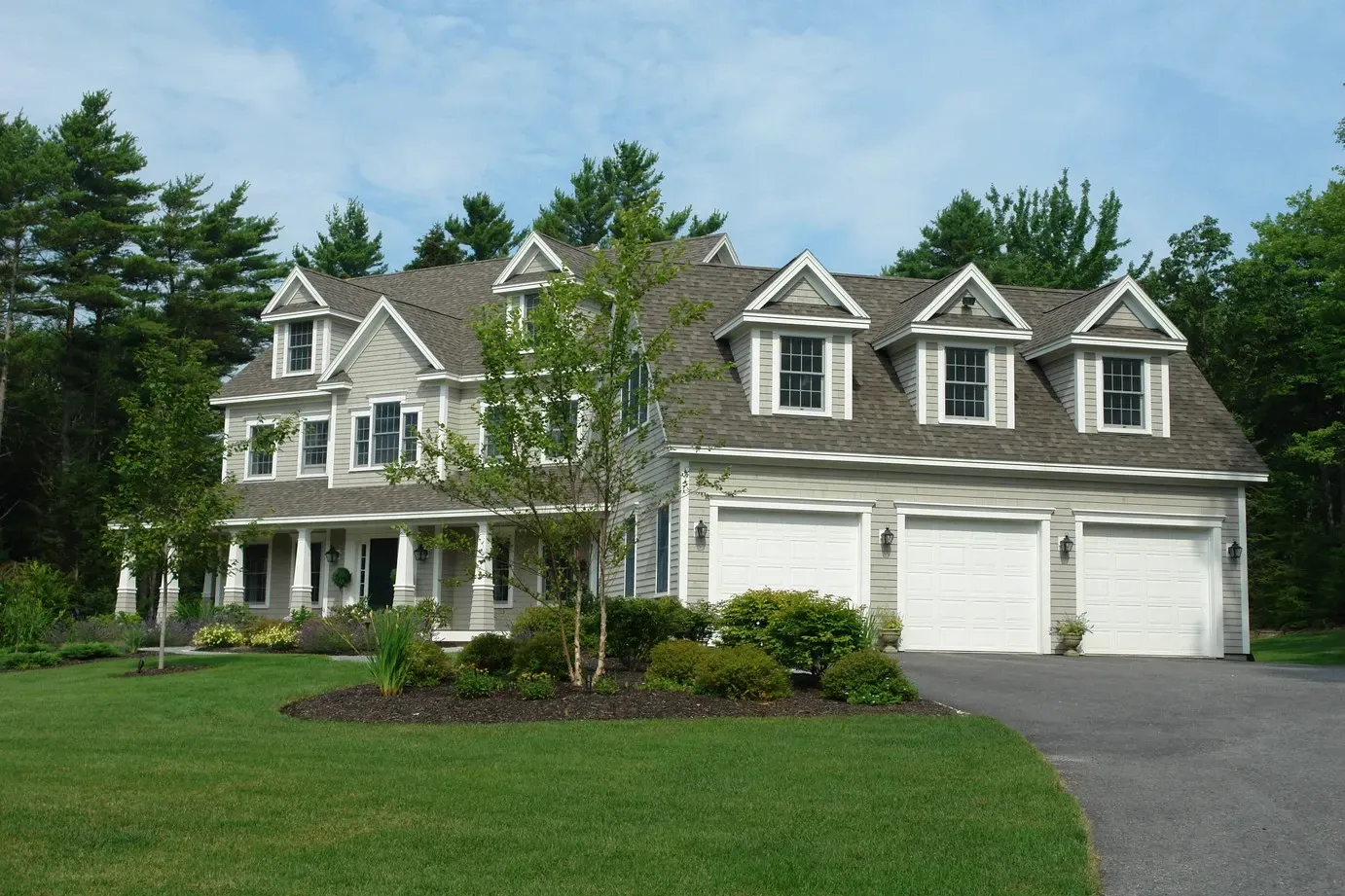 Custom Colonial home in Scarborough, Maine, with three garage doors and a front drive