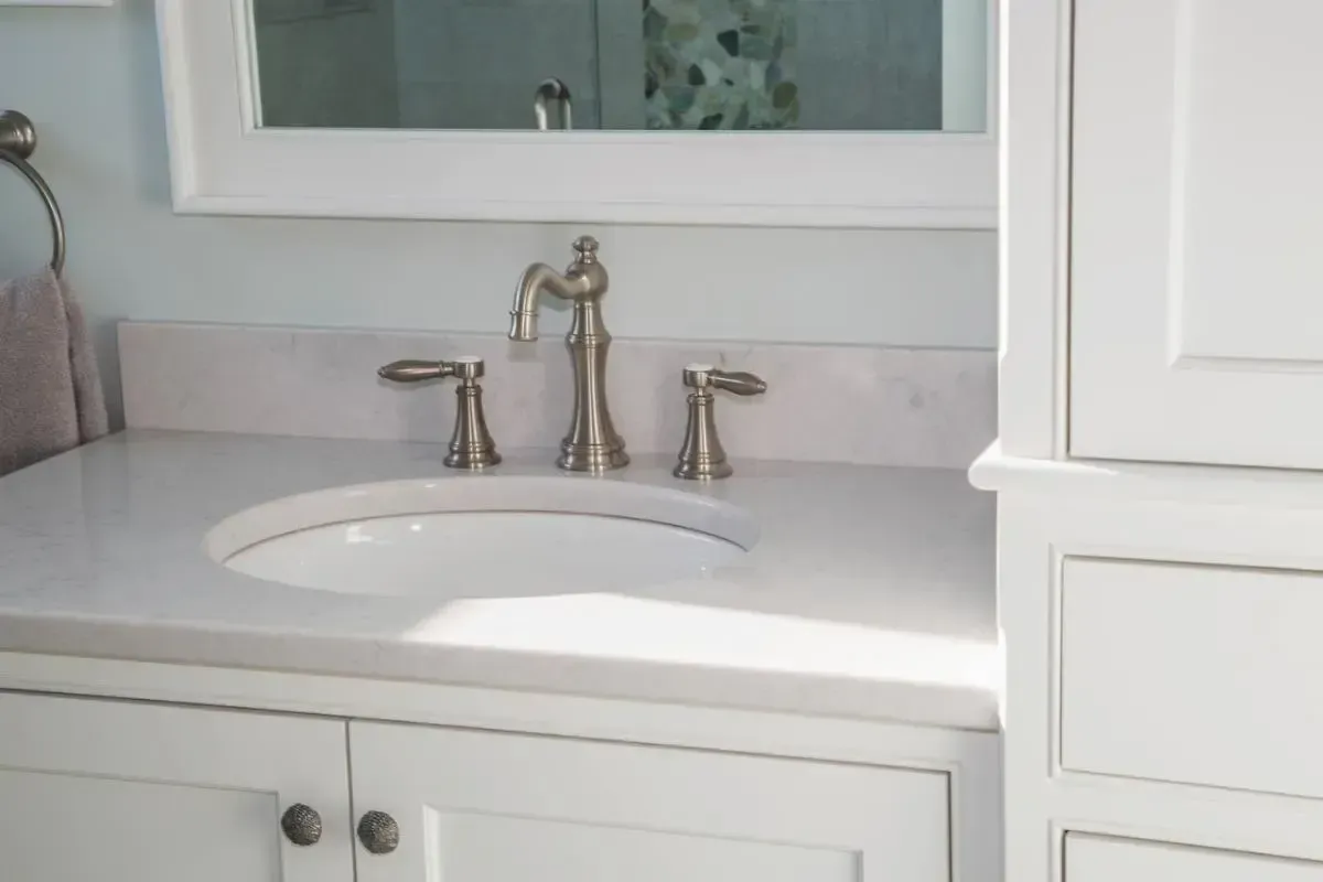Bathroom vanity with a sink, mirror, and fitted cabinets