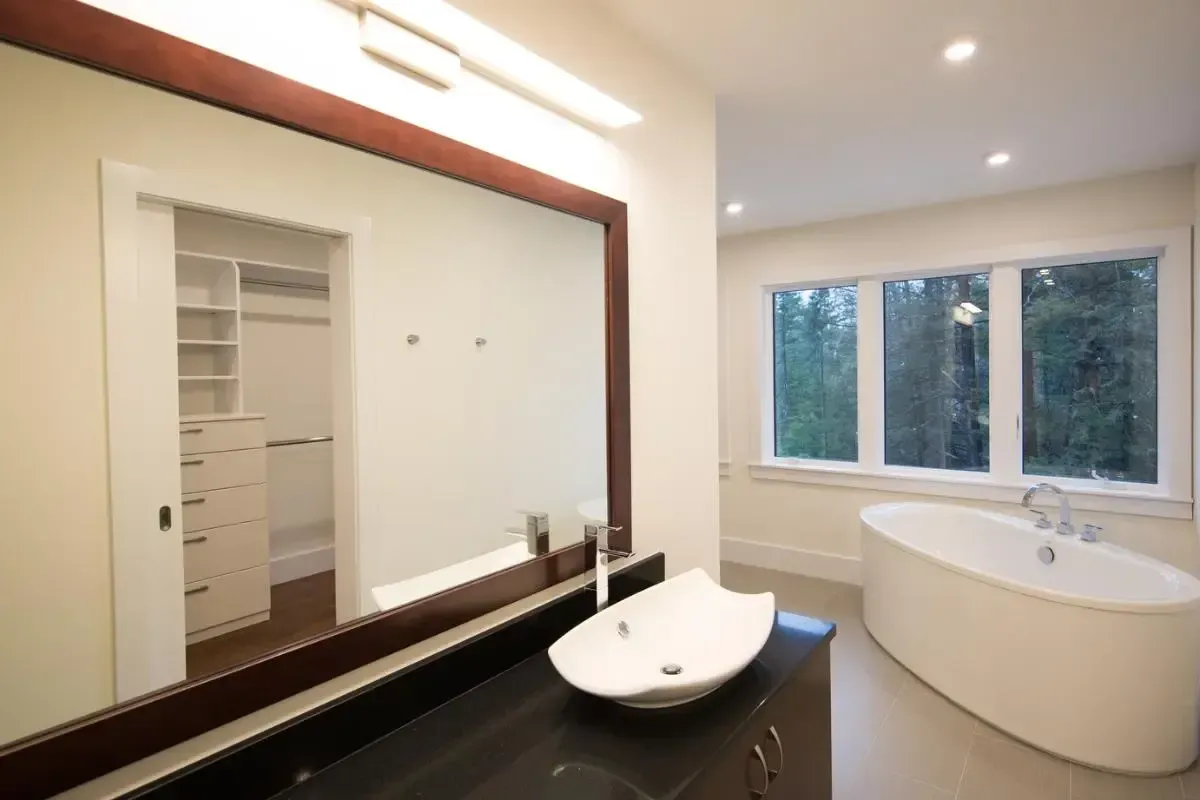 Bathroom with a large mirror, sink, and bathtub