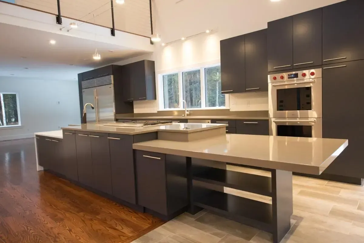 Kitchen with black cabinetry, stainless-steel appliances, and a large island