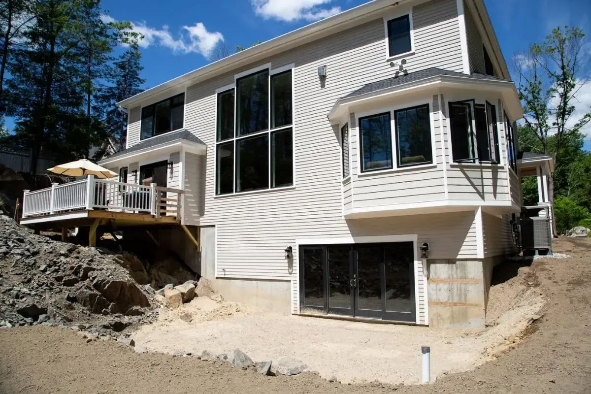 White two-story home with broad windows and a large deck