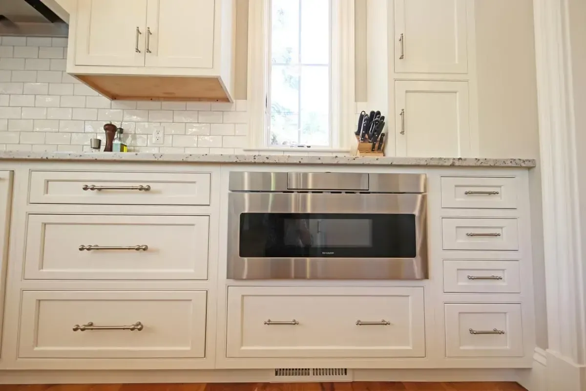 White kitchen cabinetry with a stainless-steel microwave