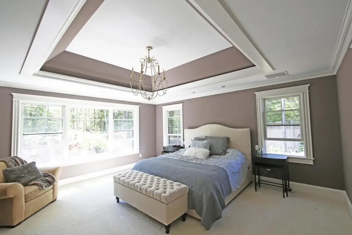 Bedroom furnished with a large bed and a sitting sofa