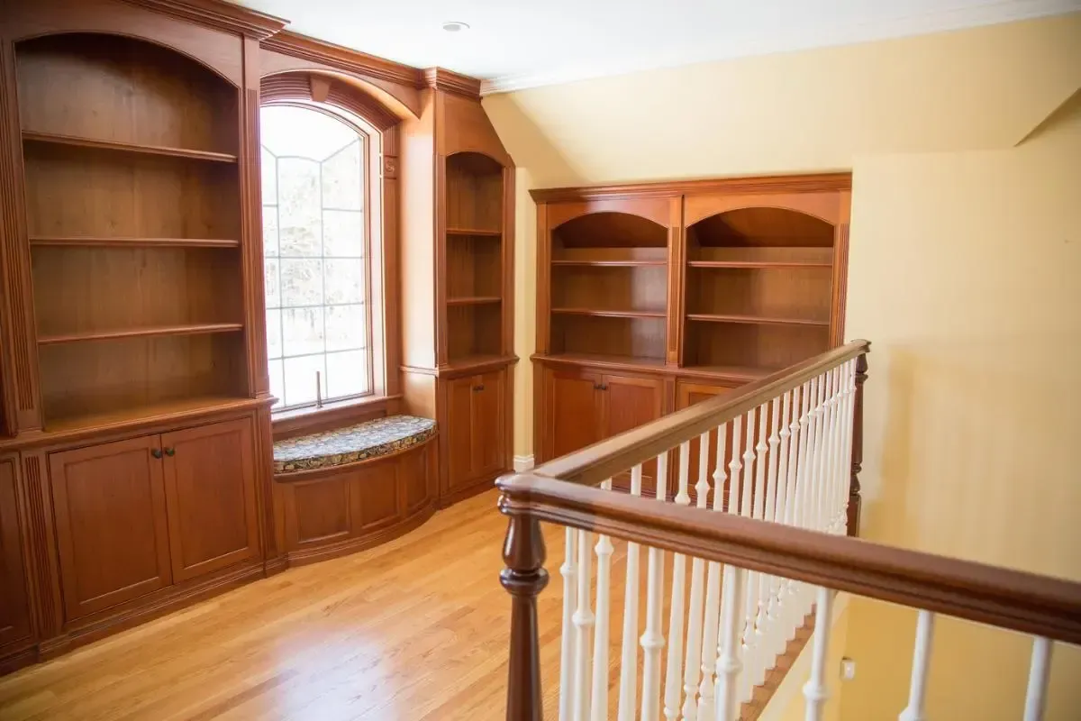 Built-in wood shelving beneath a large window