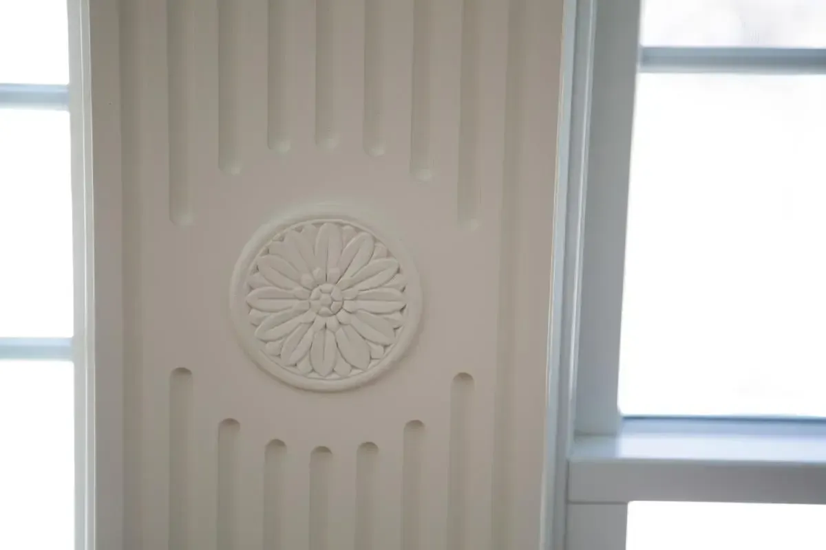 Close detail of a circular decorative feature set into a white wall