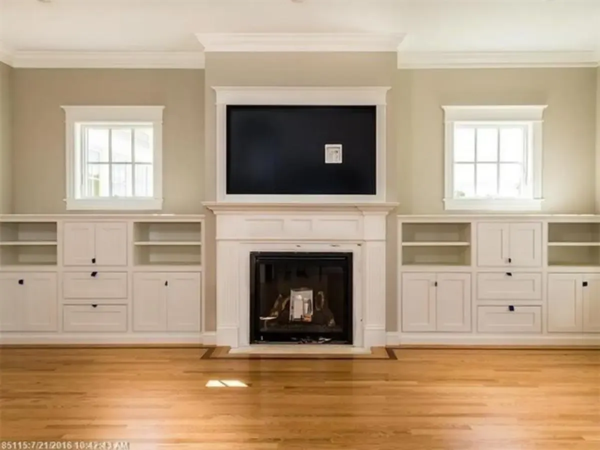 Living room fireplace framed by built-in shelving
