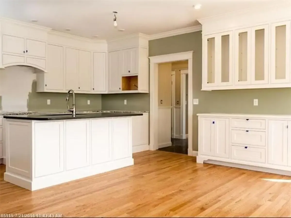 Unfurnished kitchen with white cabinets and hardwood floors