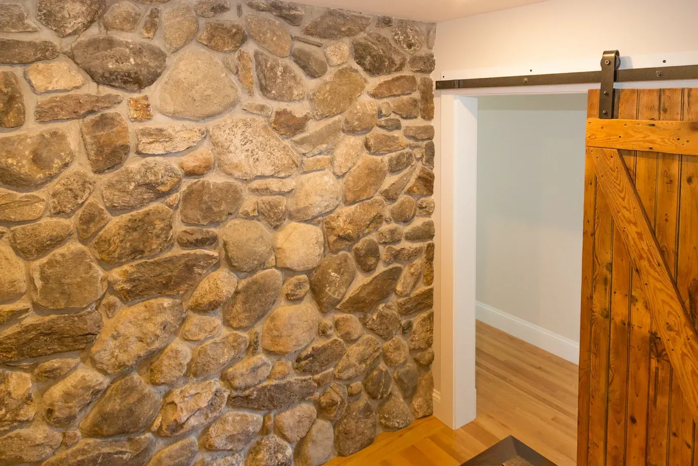 Stone wall and sliding barn door inside the home