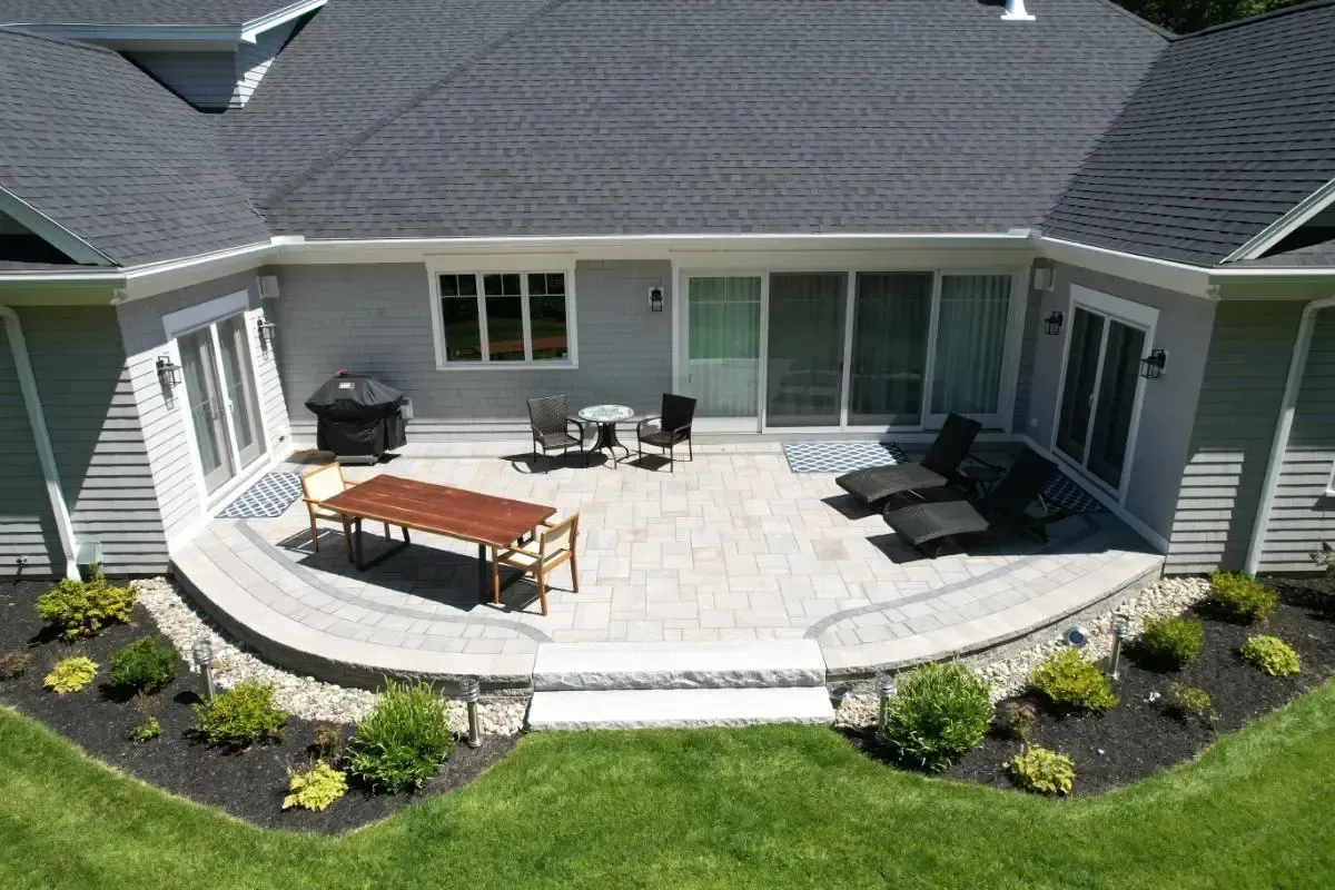 Outdoor patio with a table and chairs beside the Shore Road home