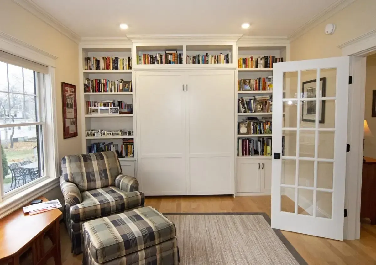 Reading area with an upholstered chair, ottoman, and bookshelves