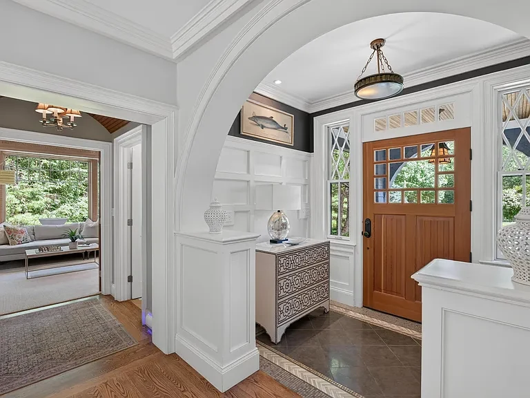 Entry with an arched millwork opening and a view through the main living spaces