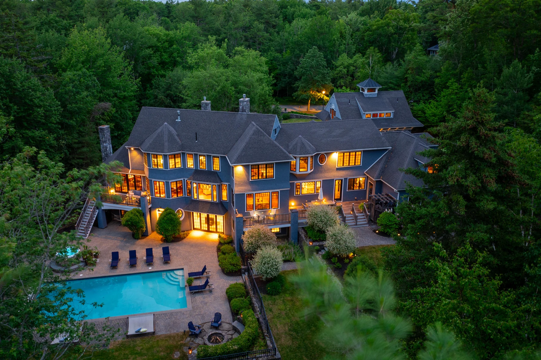 Dusk view of Tiger Lily Lane Estate with illuminated rooms and the pool terrace