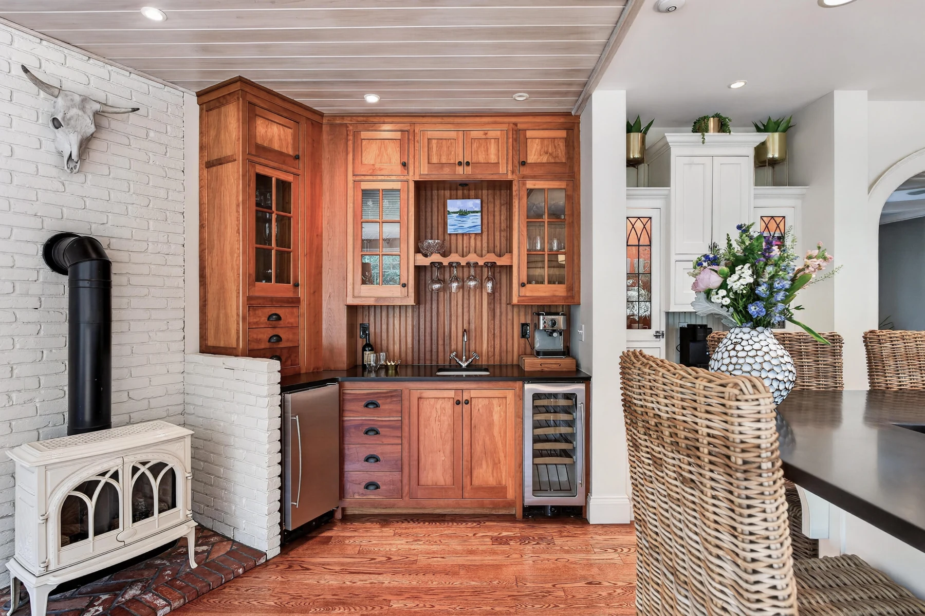 Wood beverage cabinetry and a sink beside the dining area