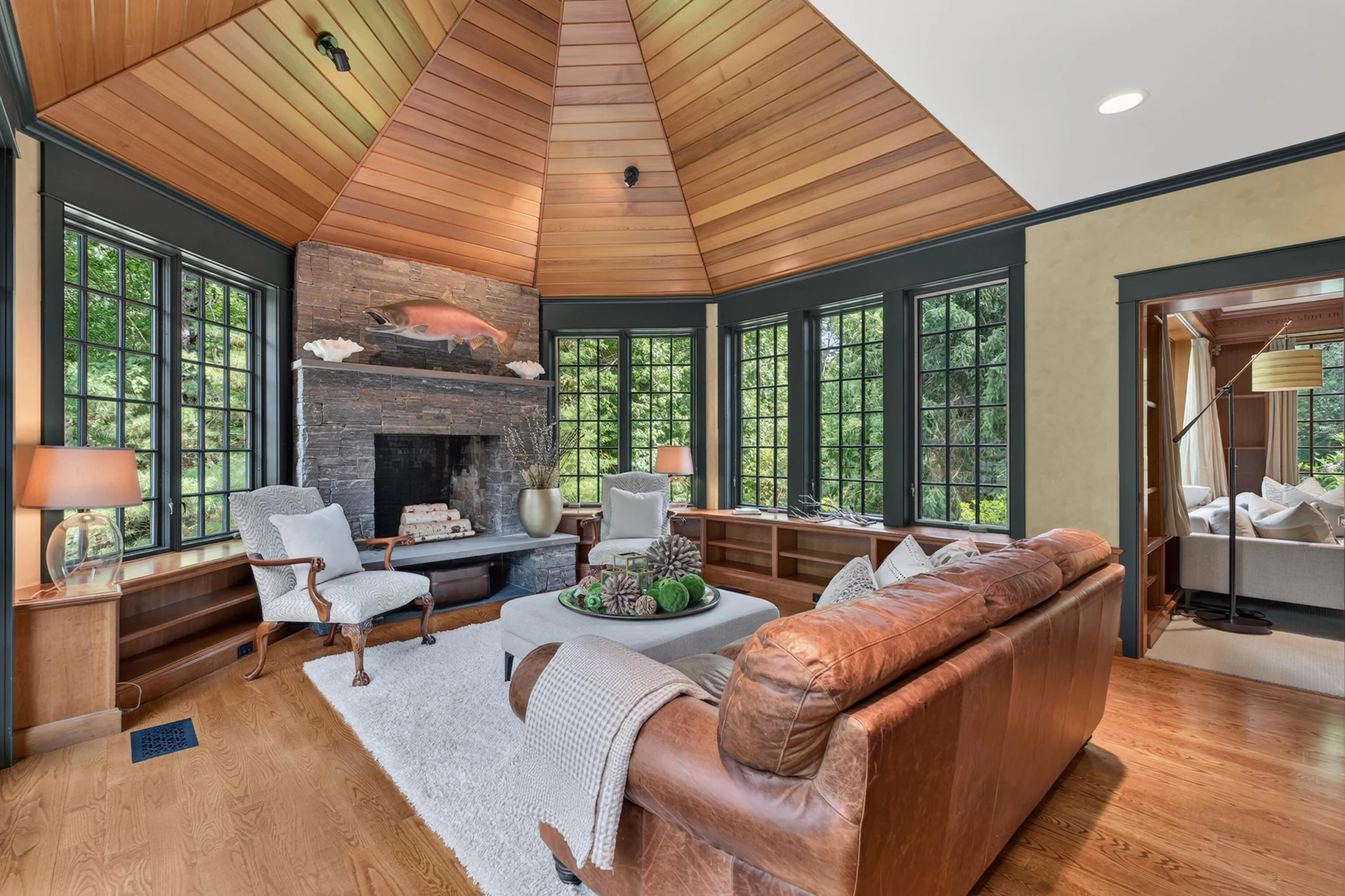 Sitting room with a vaulted wood ceiling and stone fireplace