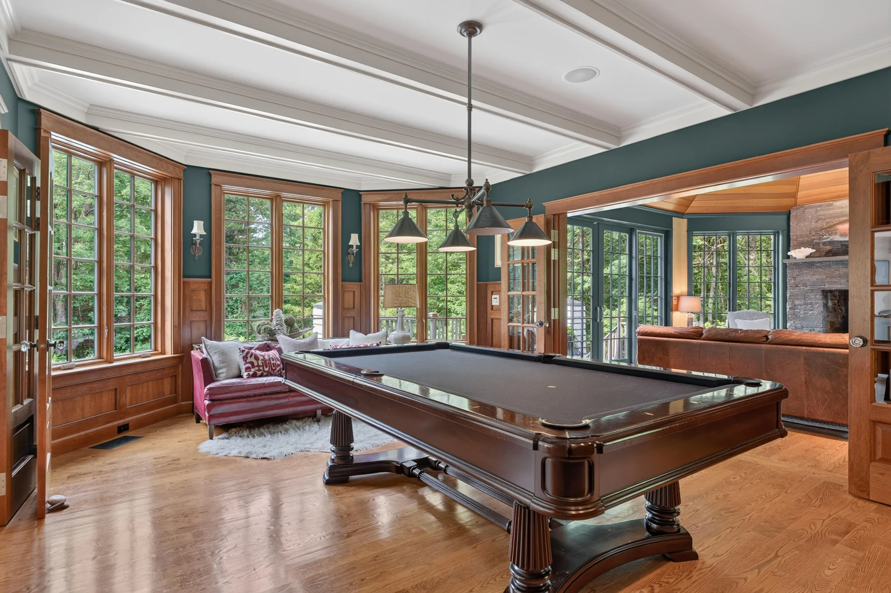 Billiards room with fitted shelving and windows overlooking the grounds
