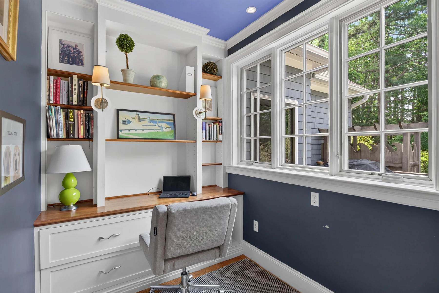 Fitted desk and shelving beside a broad window