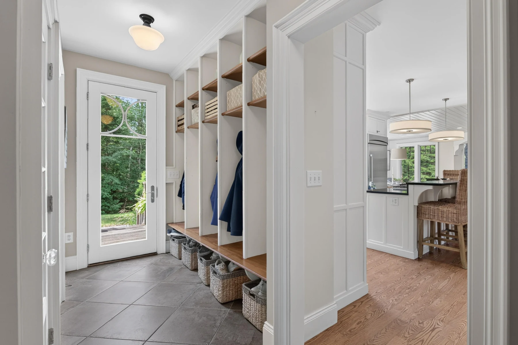 Mudroom with a built-in bench, coat storage, and adjoining sink