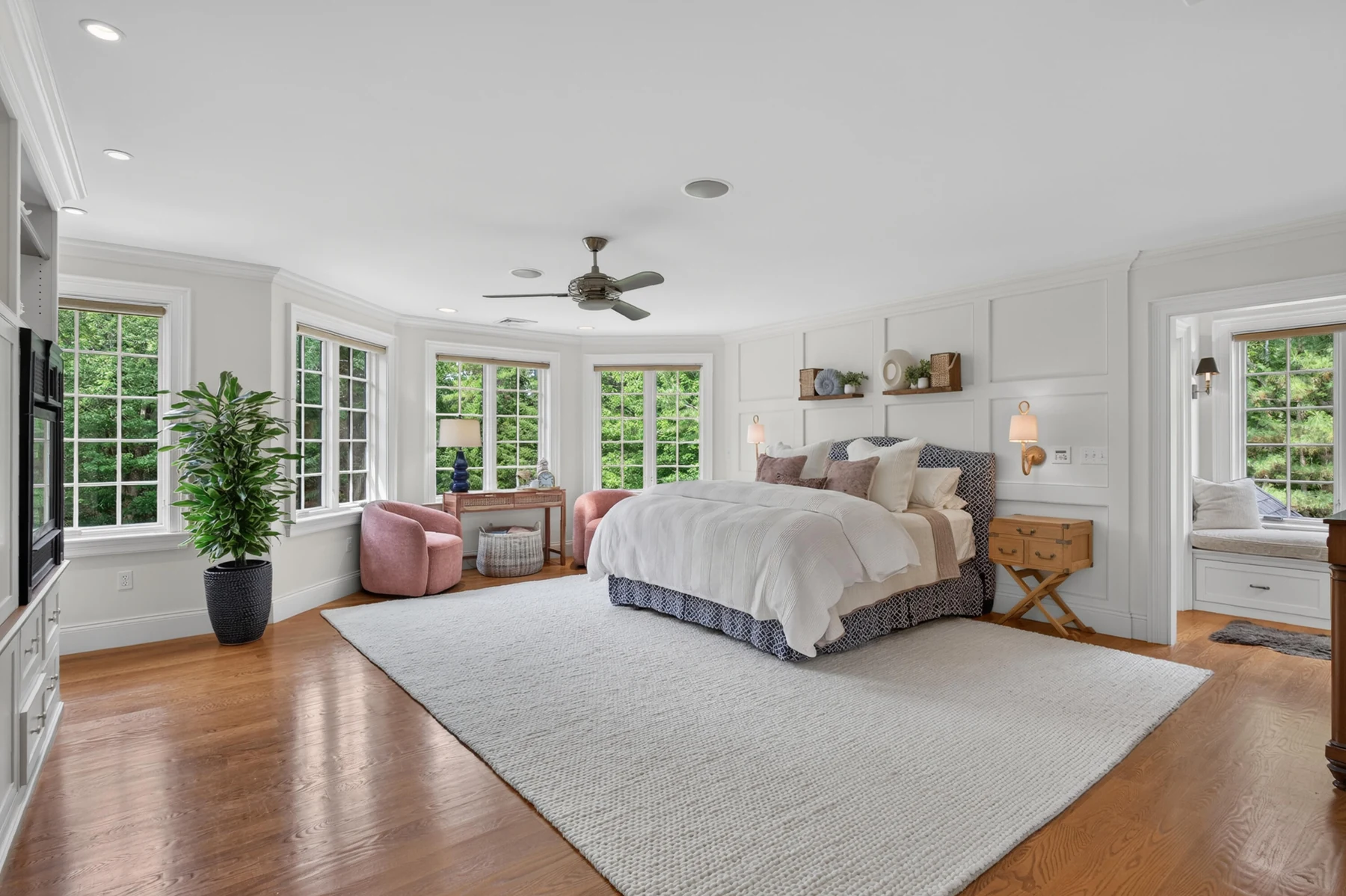 Primary bedroom with broad windows and a sitting area