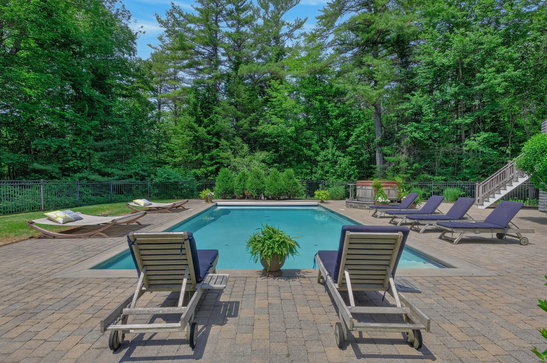 Pool terrace with loungers and mature trees