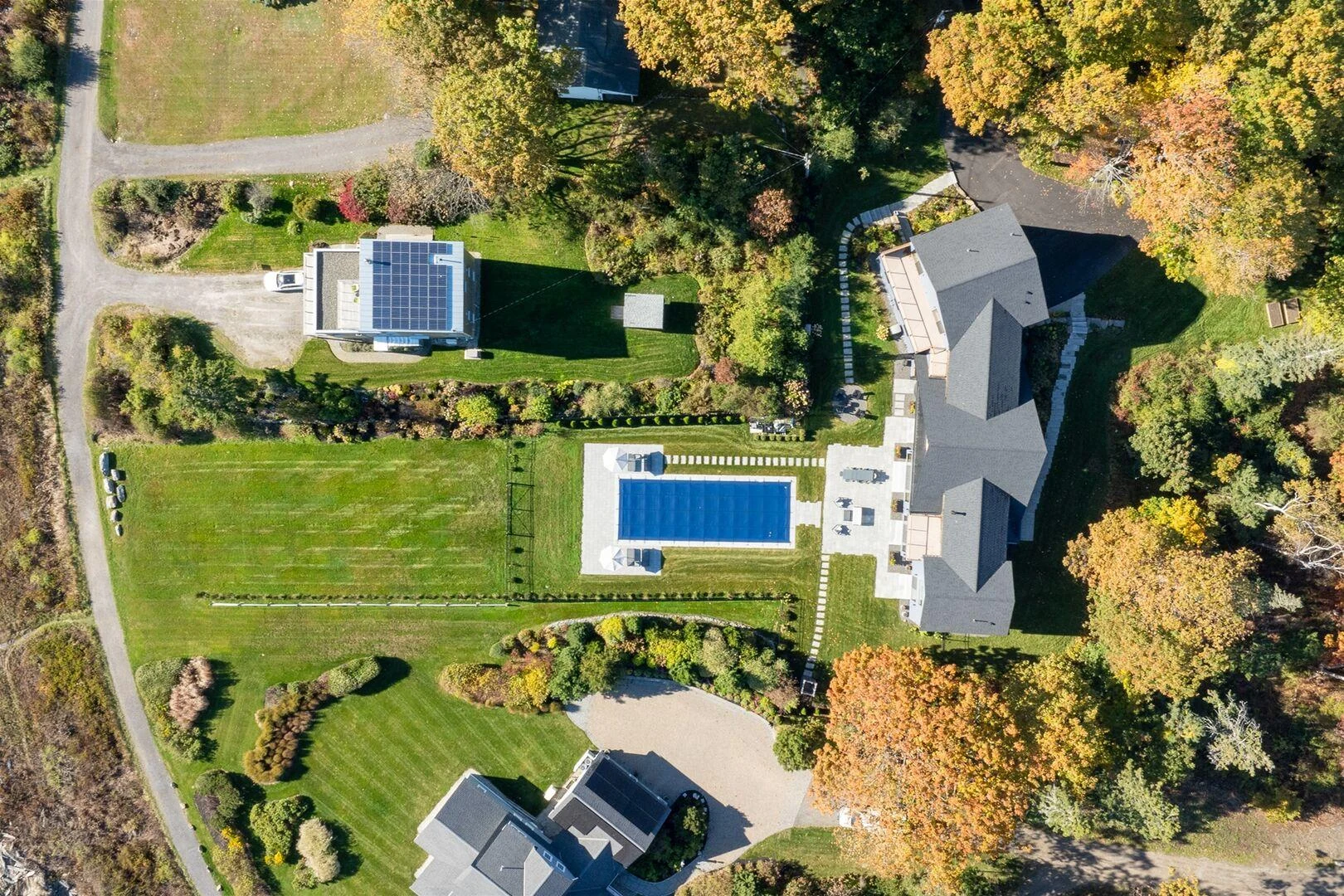 Overhead view of the Trundy Point residence, swimming pool, lawn, and landscaped grounds