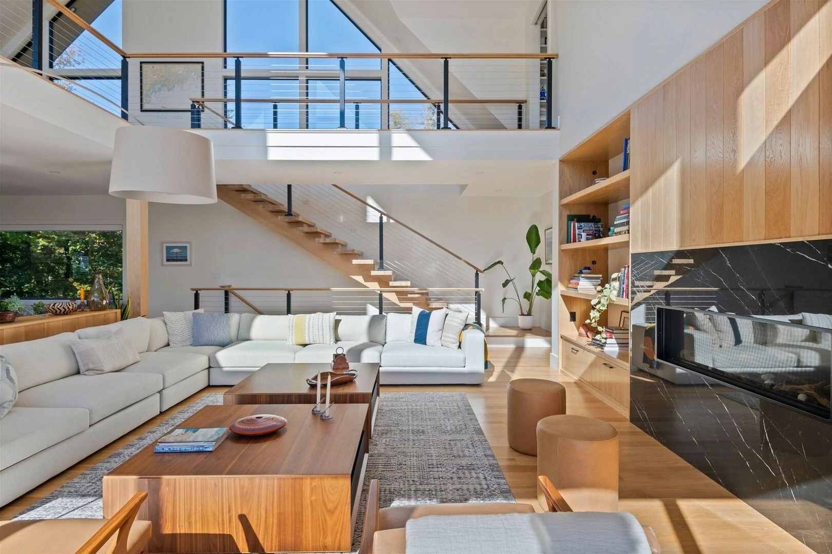 Wood fireplace wall beside the floating staircase and upper gallery
