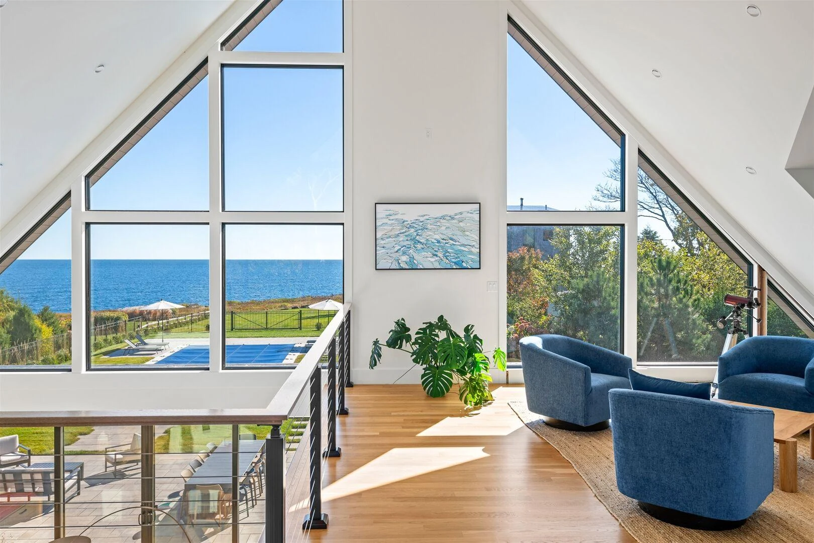 Upper landing with cable railings and broad ocean views through gable windows