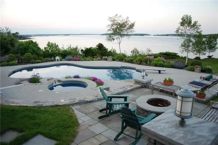 Shore Road estate's curved pool, spa, and stone terrace overlooking the water