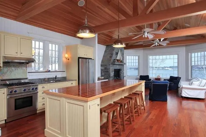 Kitchen with a warm wood ceiling, stone fireplace, and long island