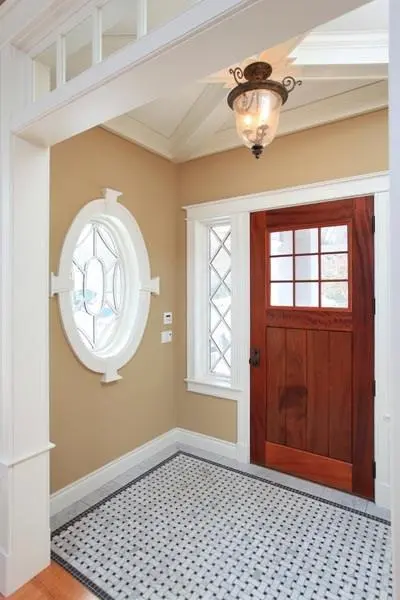 Entry hall with a red front door and circular window